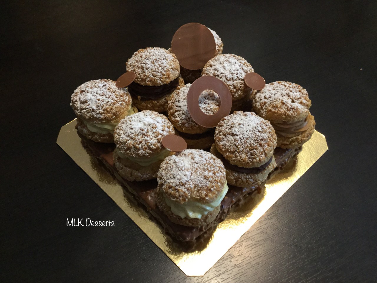 Choux Crème pâtissière Vanille, Chantilly chocolat et Crémeux praliné sur un biscuit glaçage&nbsp;rocher